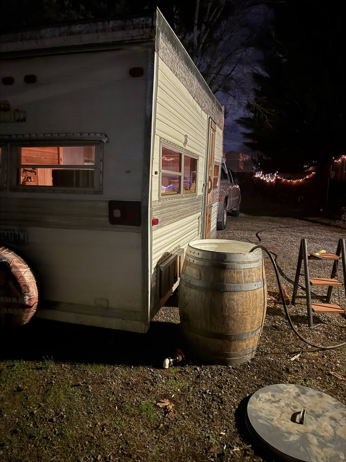 The Cousin Eddie lit from inside at night, cold plunge barrel alongside