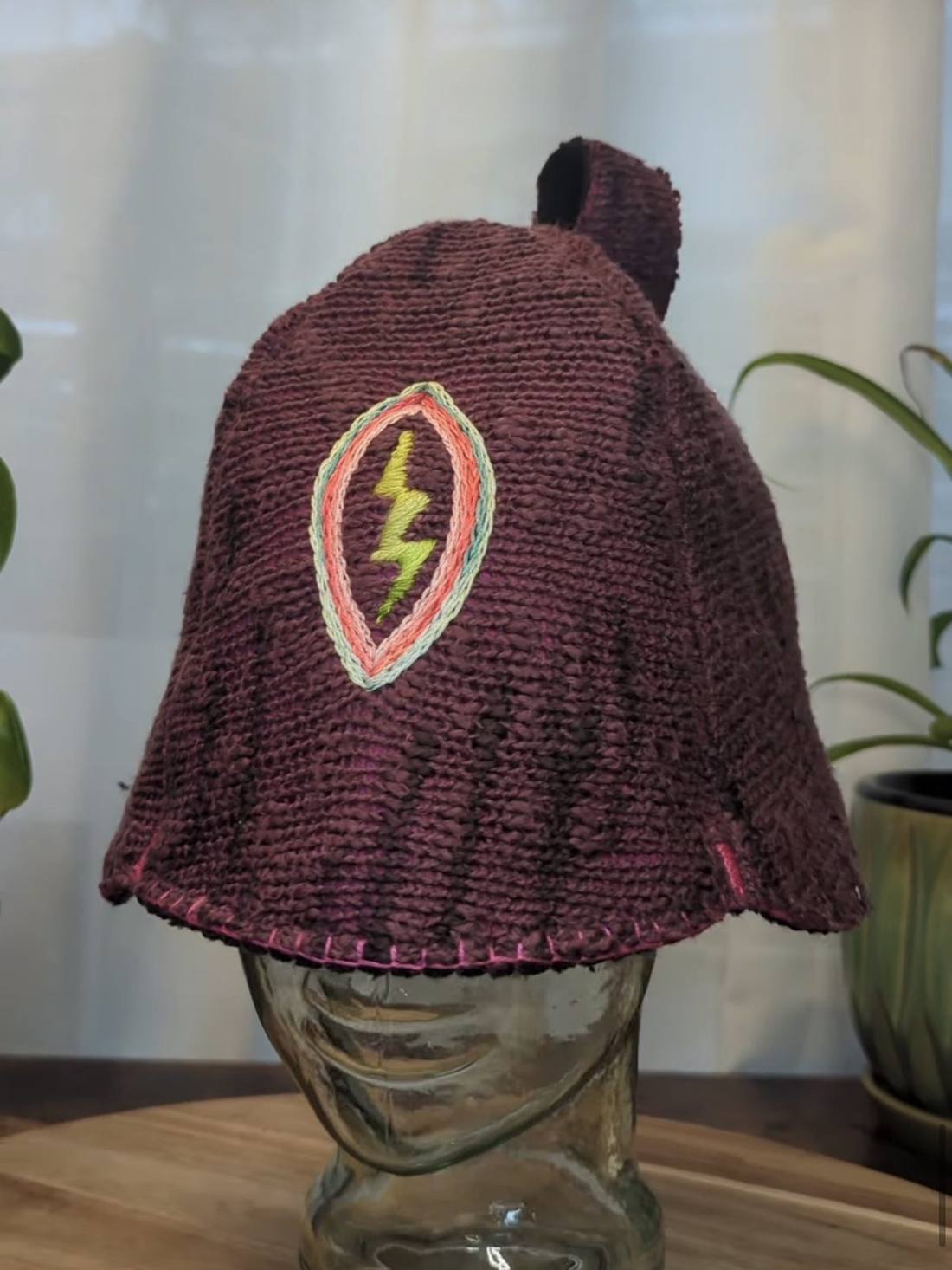 Maroon knit sauna hat with an embroidered lightning bolt