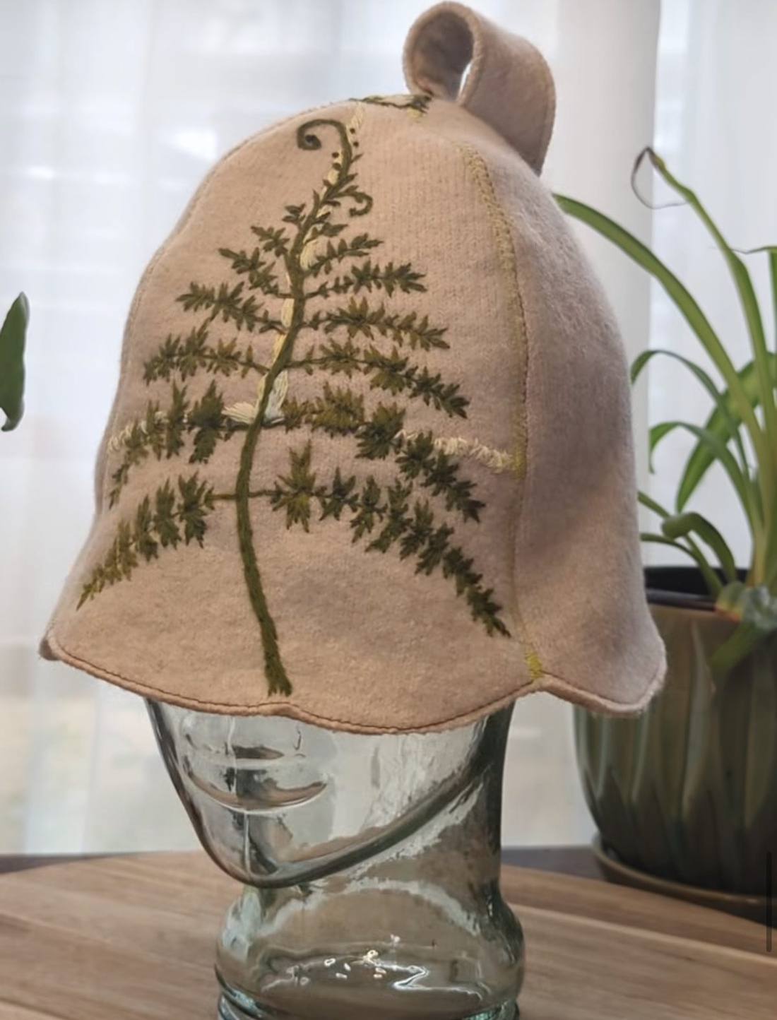 Cream wool sauna hat embroidered with a green fern