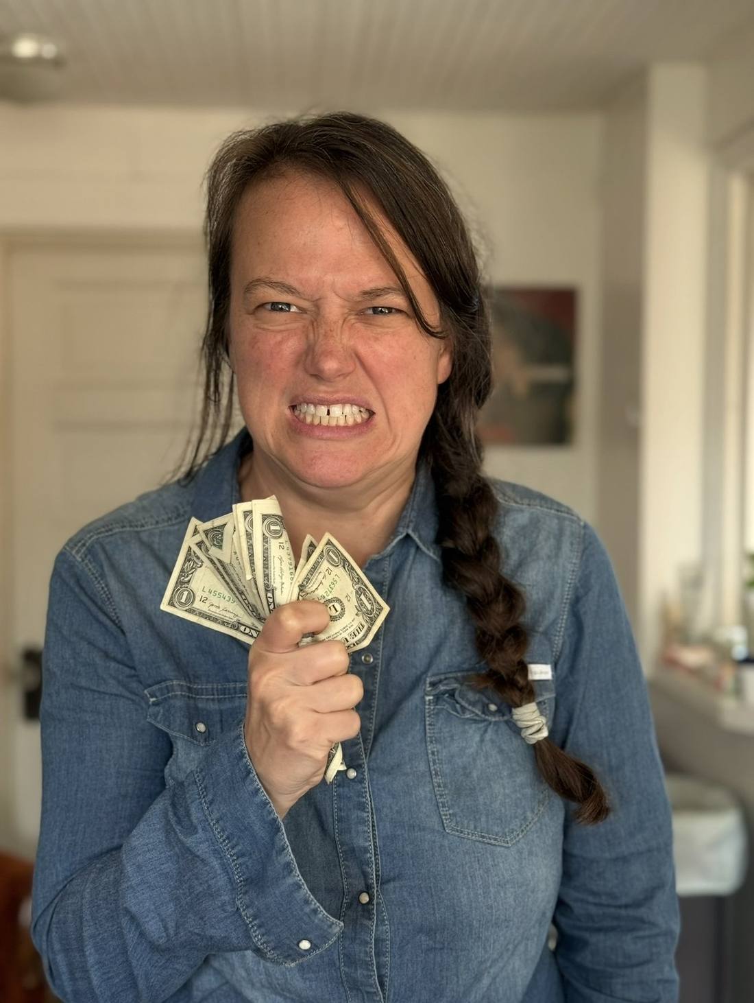 Jelli holding out a fistful of dollar bills, grinning
